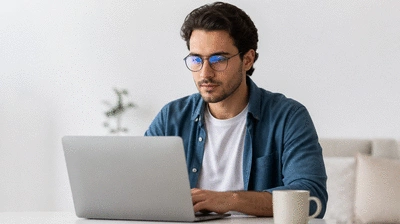 User with a laptop and blue light glasses